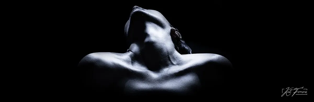 Abstract black-and-white boudoir portrait using light and shadow to suggest the outline of a woman