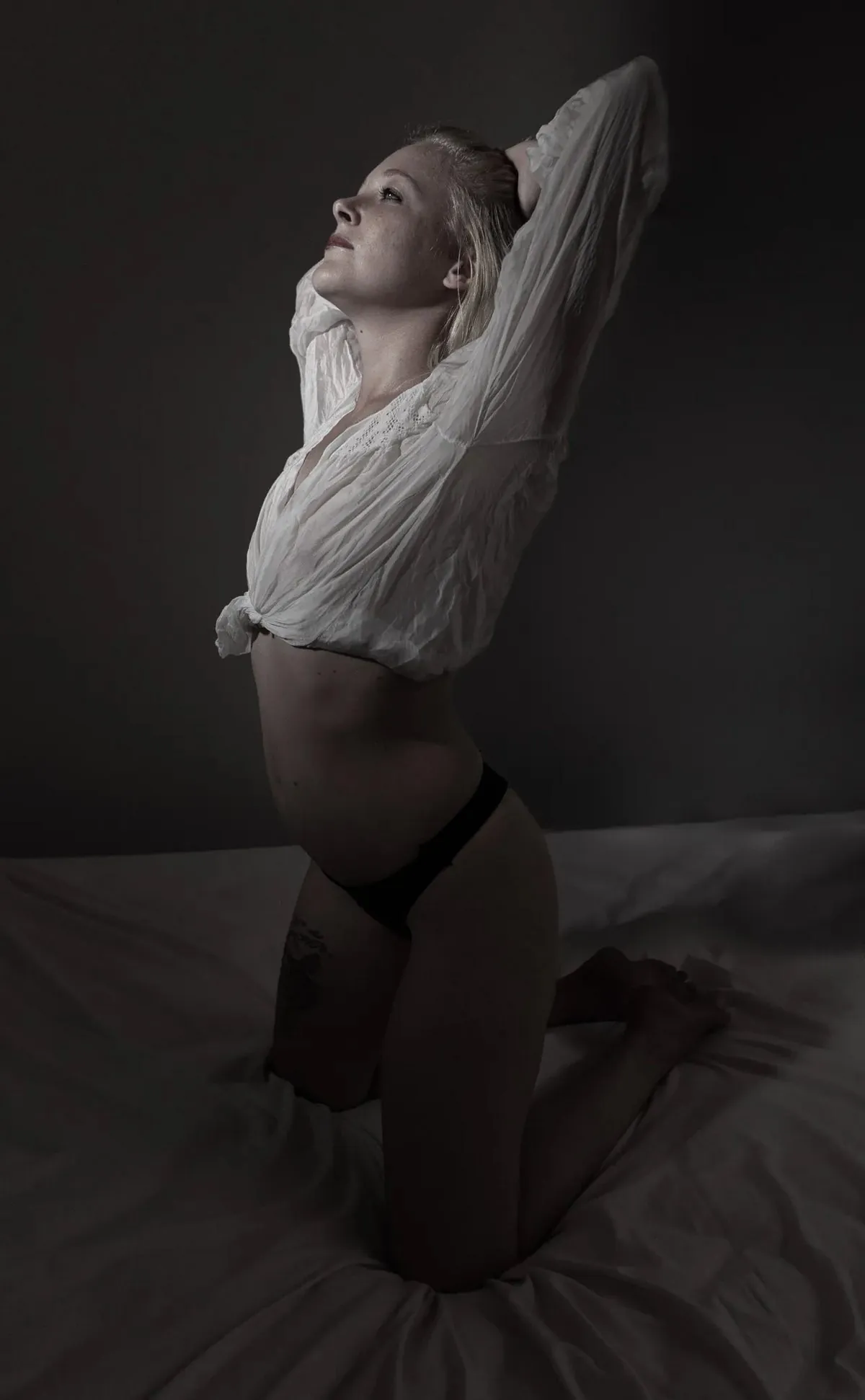 Full-length boudoir portrait of Julie kneeling in an oversized white shirt
