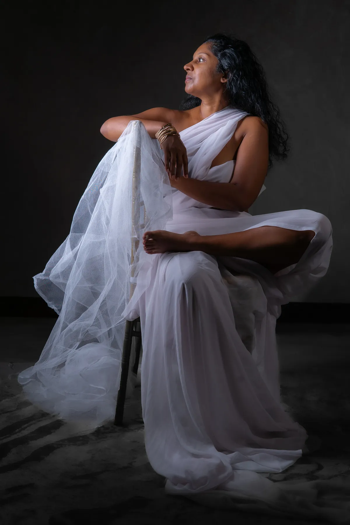 Creative studio portrait of Natacha Boodhoo moving in a flowing white dress
