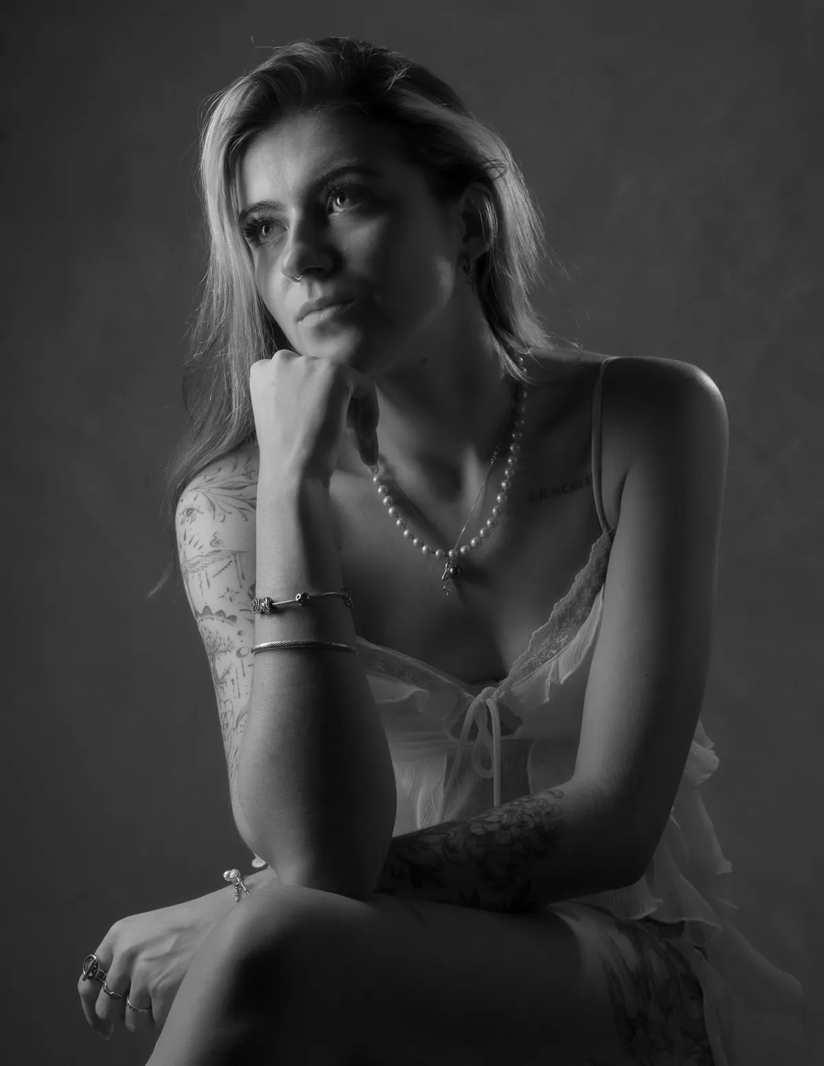 Seated black-and-white glamour portrait of Thaiss Windenberger in soft studio light
