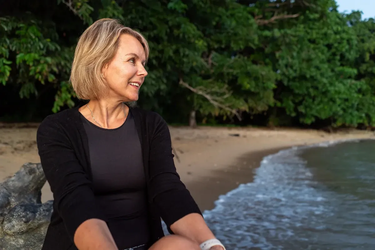 Portrait décontracté de Deborah assise près de la plage