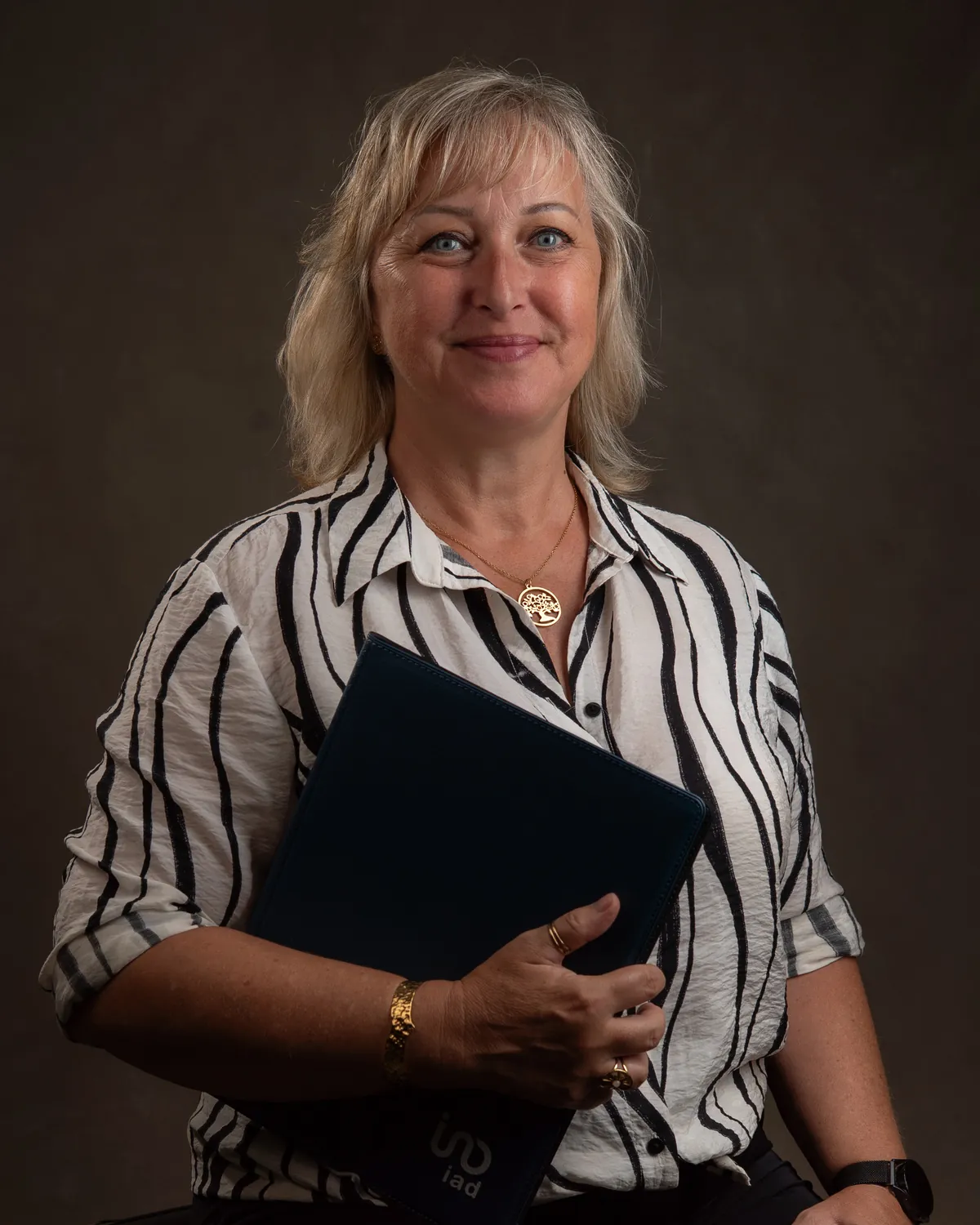 Professional studio headshot of a woman against a dark neutral background