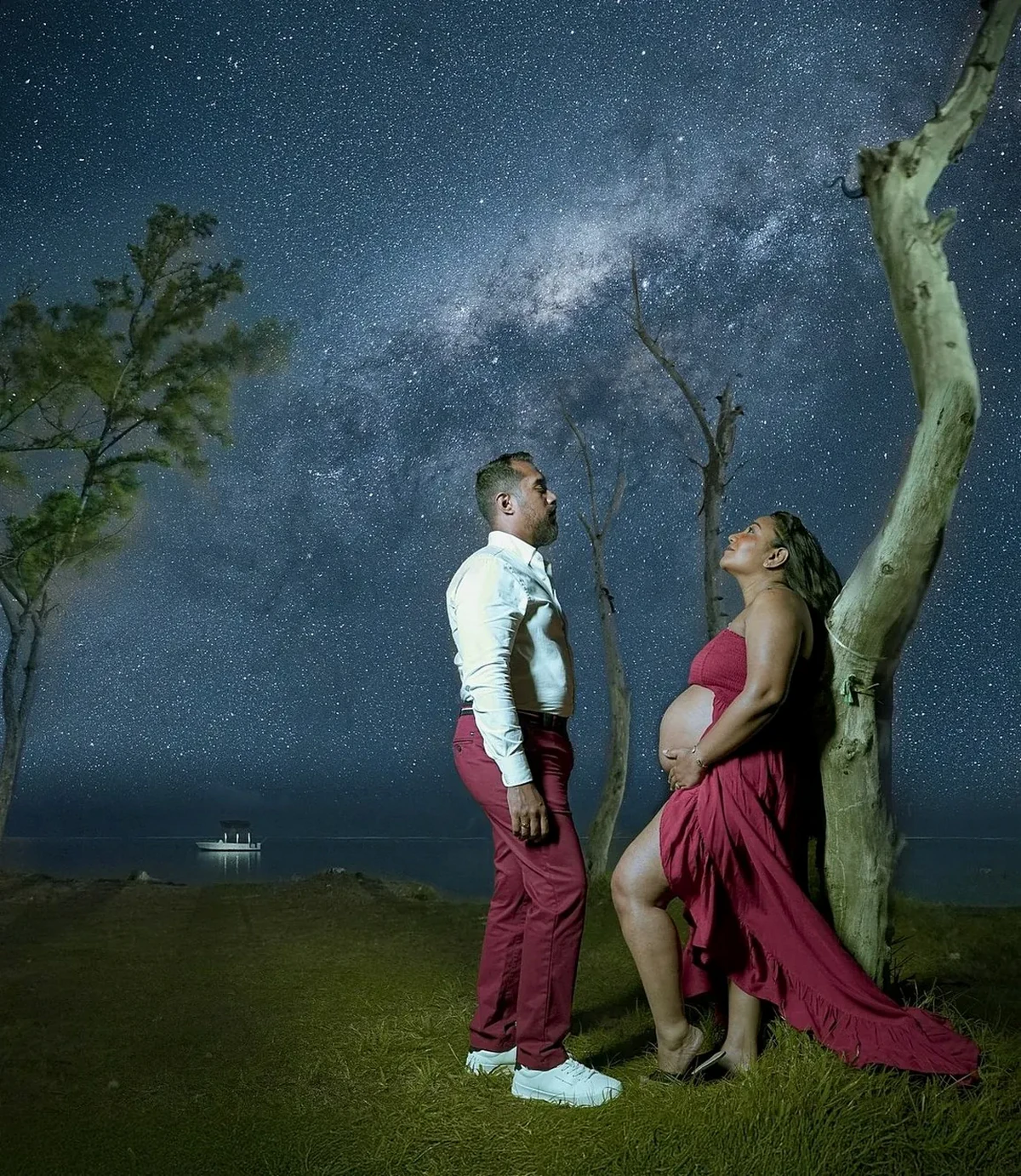 Pregnant couple illuminated beneath the Milky Way during a night portrait session in Mauritius