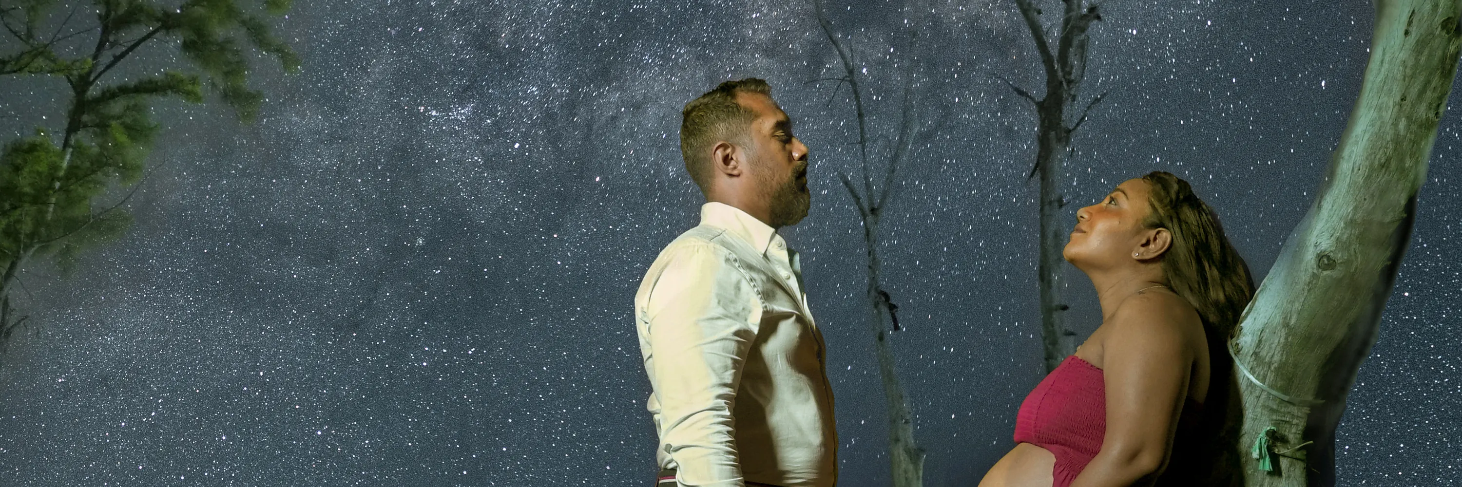 Couple illuminated beneath a star-filled night sky during a portrait session in Mauritius