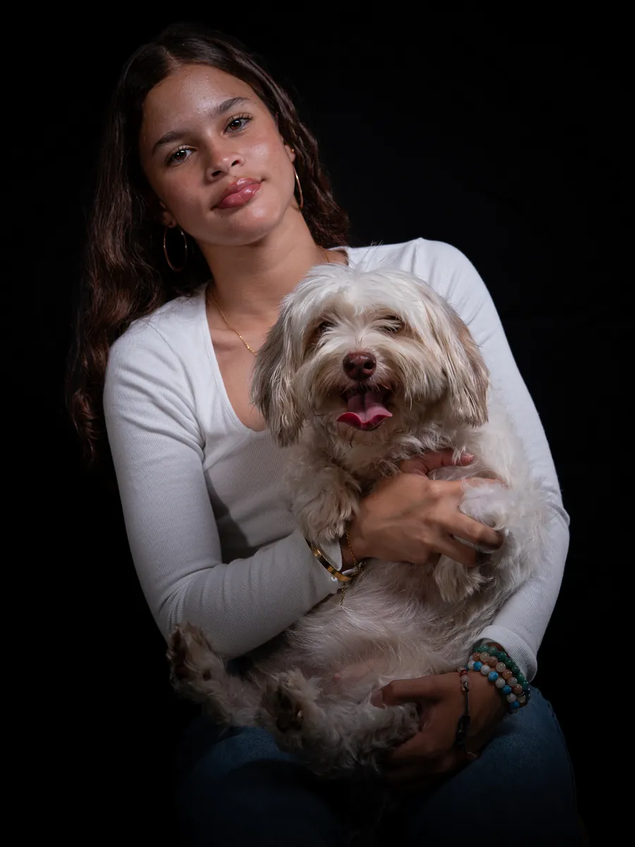 Adolescente tenant son chien pendant une séance photo détendue en studio