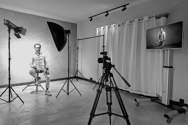 Full studio setup at Nude Art showing lights, camera, and TV display during an indoor shoot